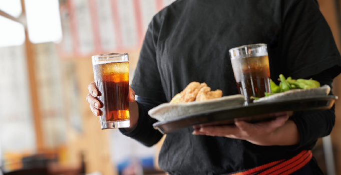 居酒屋で配膳をする店員の写真